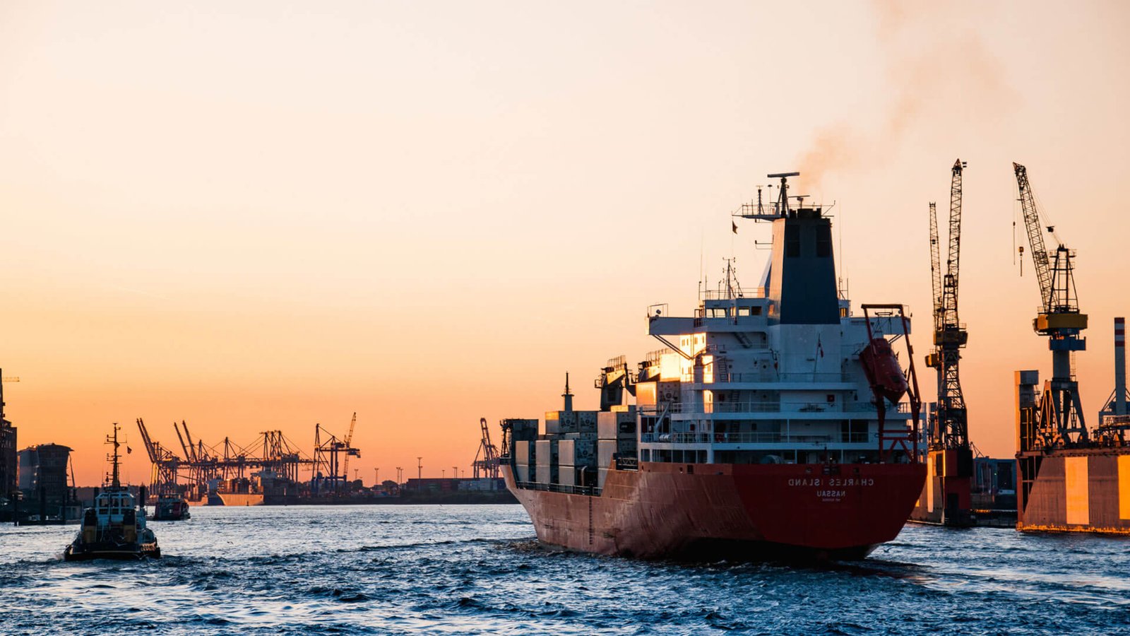 A shipping container being loaded onto a cargo ship, representing international trade